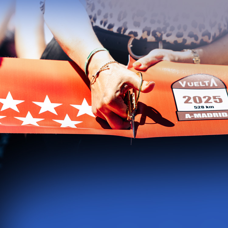 Persona cortando una cinta de la Vuelta ciclista